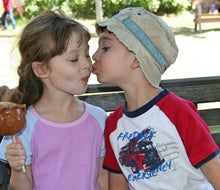 Two kids share a caramel apple. Photo by Meghan Rose